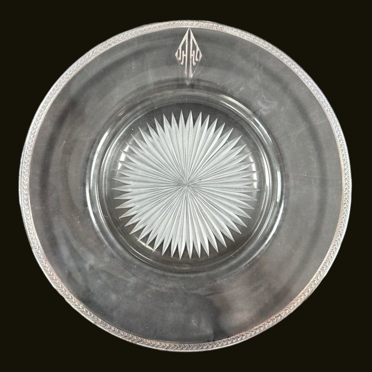 A lot of 13 antique cut glass dinner plates with silver encrusted rims having a star burst design to: A lot of 13 antique cut glass dinner plates with silver encrusted rims having a star burst design to center. Rims with stylized leaf design. 12 plates have a silver monogram. Please note the thirteent