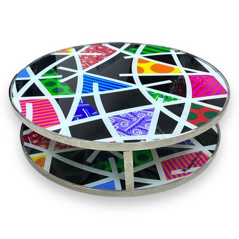 A Romero Britto glass top round coffee table with crhomed metal base and double glass. Measures (1 of 6)