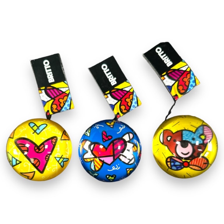 A lot of 5 Romero Britto pop-art domed glass paperweights of various designs. Each measures approx.: A lot of 5 Romero Britto pop-art domed glass paperweights of various designs. Each measures approx. 1 1/2" height x 3" diameter. Appear to be new in box. JD/B15/SH:15B