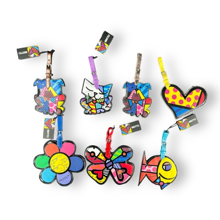 A lot of 7 Romero Britto pop-art leather luggage tags of varous designs. Each measures approx. 9: A lot of 7 Romero Britto pop-art leather luggage tags of varous designs. Each measures approx. 9 1/4" length more or less. Some show use and some new with tags...see photos. JD/B15/SH:15A