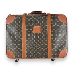 A Louis Vuitton classic brown leather jacquard monogram rolling softside suitcase luggage. Measures: A Louis Vuitton classic brown leather jacquard monogram rolling softside suitcase luggage. Measures approx. 22" height x 25" width x 8 3/4" depth overall including handle and wheels. Used but appears