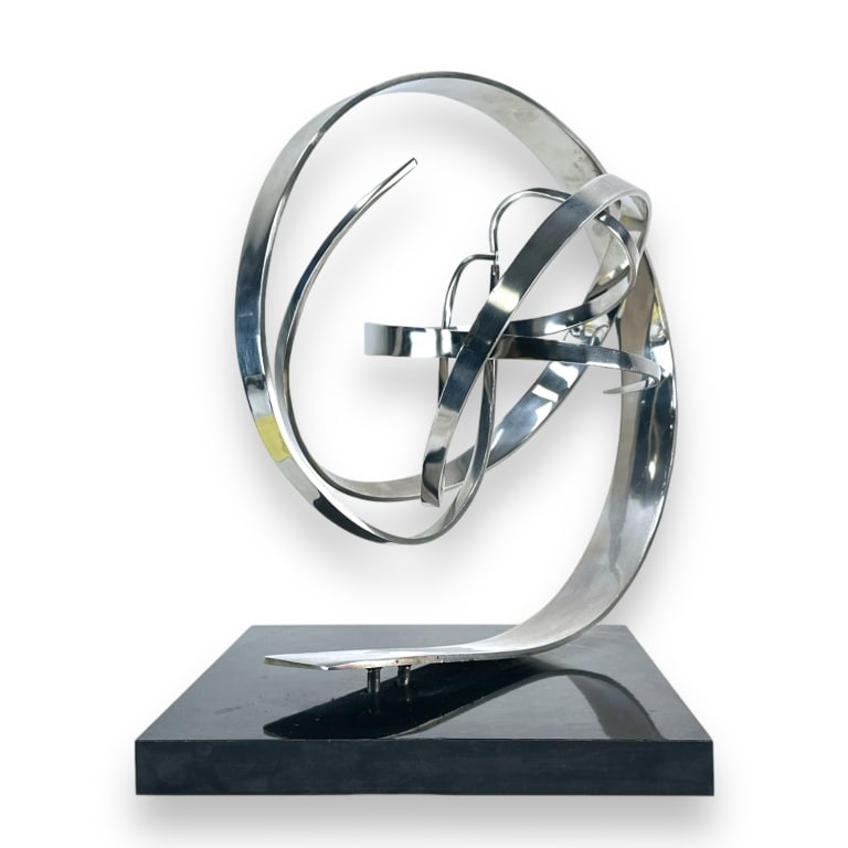 Michael Cutler (CANADIAN, 20th/21st Century) chromed metal kinitec moveable sculpture having a: Michael Cutler (CANADIAN, 20th/21st Century) chromed metal kinitec moveable sculpture having a swirling design and mounted on a black wooden plinth. Deremel signed on metal base and dated 1995. Measur