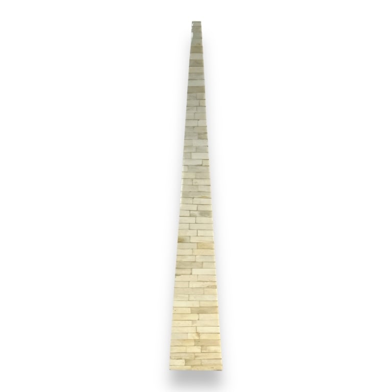 An Indian hand crafted bone veneer obelisk phallic sculpture. Retains labels to bottom. Measures: An Indian hand crafted bone veneer obelisk phallic sculpture. Retains labels to bottom. Measures approx. 26 1/4" height x 4" width x 4" depth. Appears in overall good condition. JD/B13/CB:A