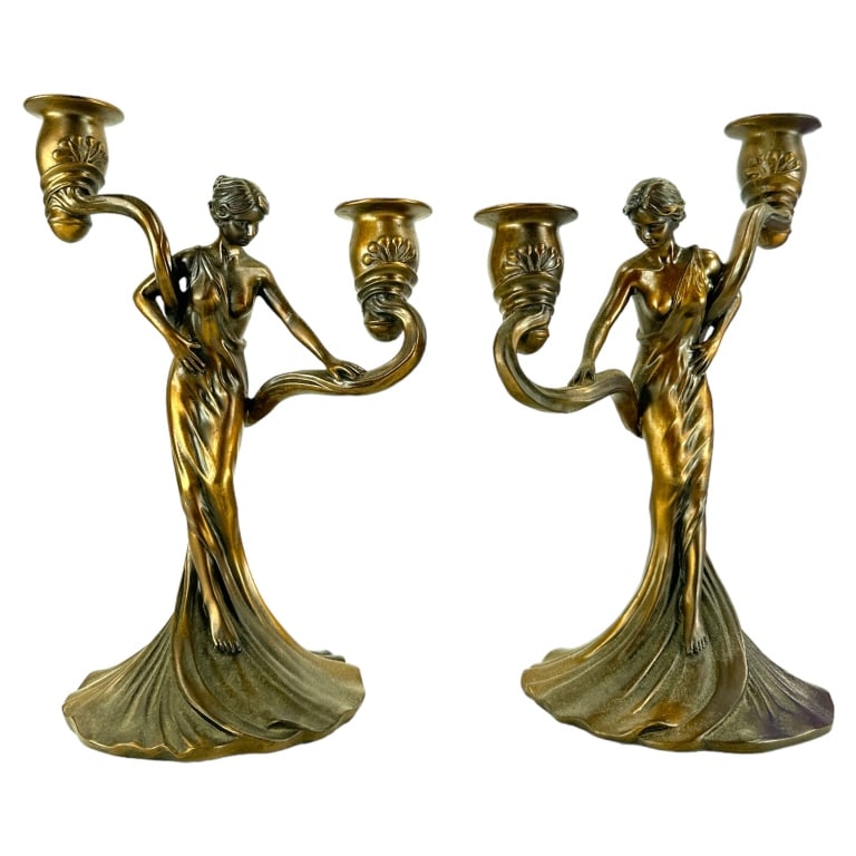 A pair of Art Nouveau cast resin figural two arm candelabra depicting a woman in flowing robe.: A pair of Art Nouveau cast resin figural two arm candelabra depicting a woman in flowing robe. Measures approx. 11 1/4" height x 8 3/4" width x 5 3/4" depth. Appears in overall good condition. JD/B13/