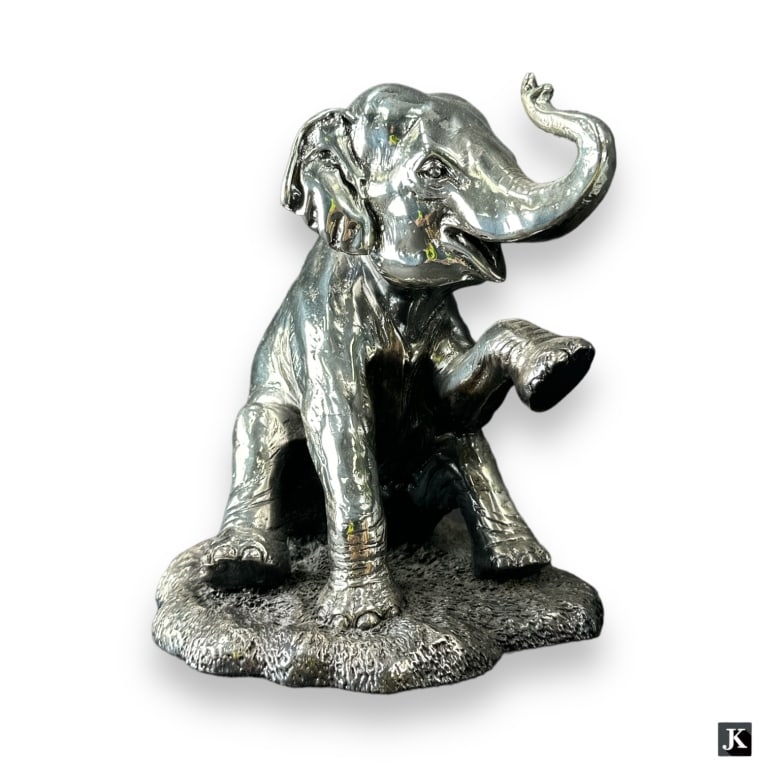 A vintage Plata Artistica Mexico 999 pure sliver animal sculpture depicting a seated elephant.: A vintage Plata Artistica Mexico 999 pure sliver animal sculpture depicting a seated elephant. Retains factory label to bottom. Measures approx. 7 3/4" height x 6 1/4" width x 6 3/4" depth. Shows typi