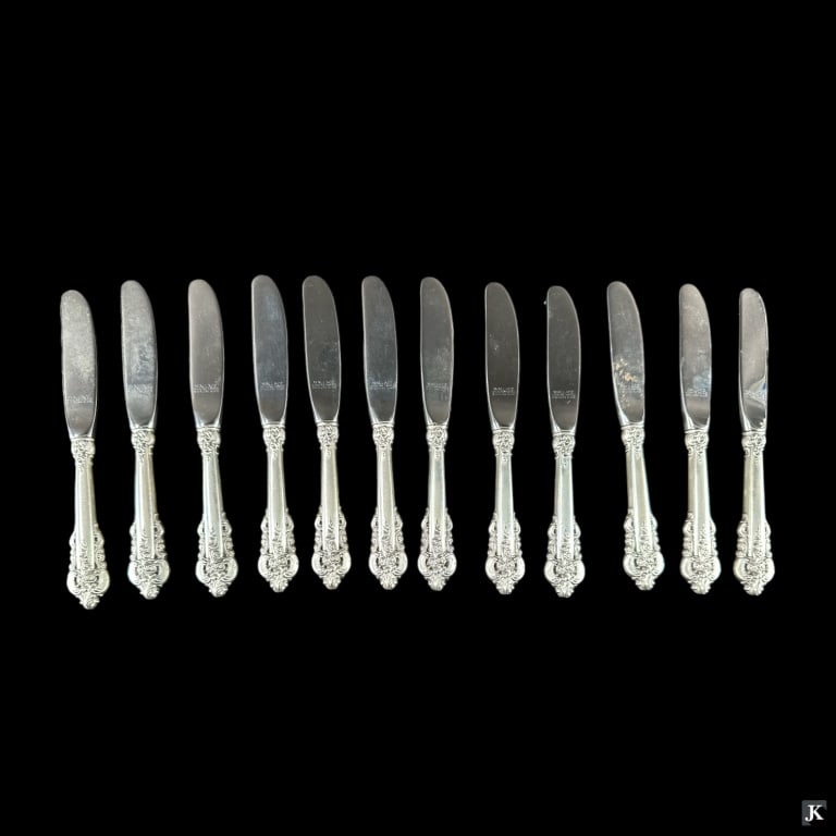 12 Wallace Grand Baroque Sterling Butter Spreaders: A set of 12 Wallace "Grand Baroque" American sterling silver hollow handle butter spreaders with stainless steel blades. Marked on blades. No monograms. Each measures approx. 6 1/4" length. JD/B13/CB: