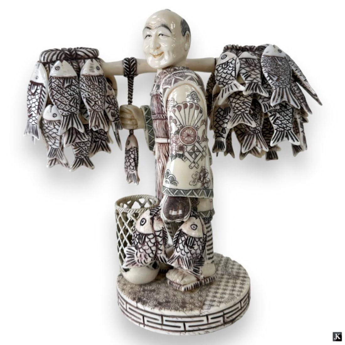 Vintage Japanese Signed Bone Fish Merchant Okimono: A fine vintage, possibly antique, Japanese carved and polychrome bone Okimono sculpture depicting a fisherman or fish merchant carrying numerous fish. Finely etched patterns to layered garb. Etched ca