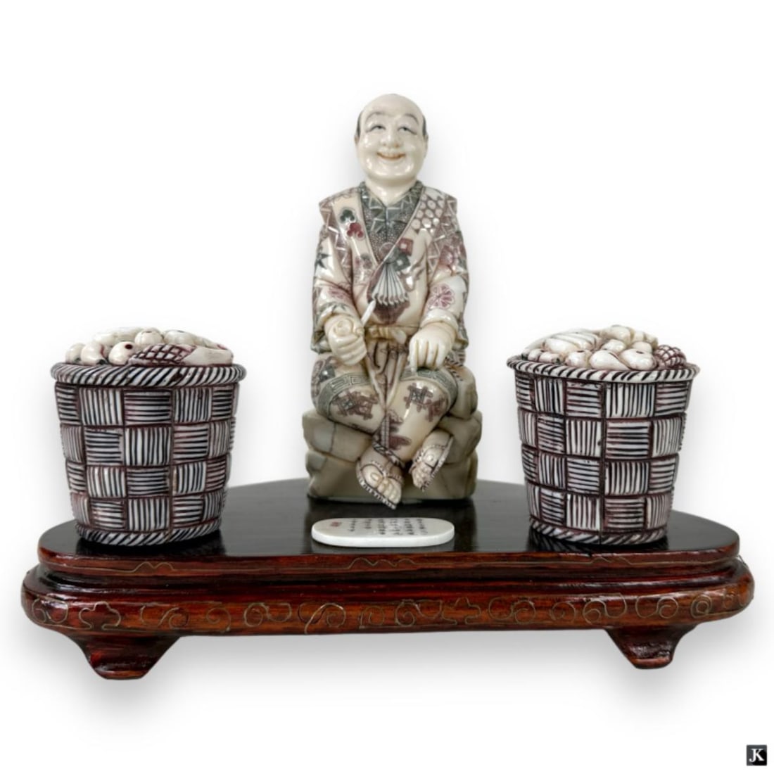 Vintage Signed Japanese Bone & Wood Okimono: A vintage Japanese hand carved bone and wood Okimono sculpture depicting a seated fruit merchant with two baskets. Mounted atop a wooden base with silver inlaid wire. Signed to applied plaque on base.