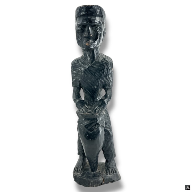 Vintage Haitian Carved Wood Figural Sculpture: Vintage Haitian Carved Wood Figural Sculpture. Depicts a man playing a Rada drum. Unsigned. Some age splits or good condition consistent with age. Measures 24" x 6" x 6". LA/B13/SH:19A