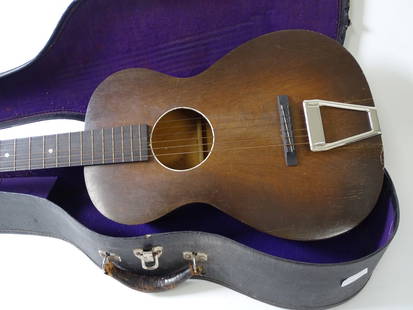 Vintage Harmony Parlor Guitar in Case: Vintage Harmony Parlor Guitar in Case. Possibly a Harmony H1000 F-41 model. As is with wear and rubbing from age and use. Case and some music books included.