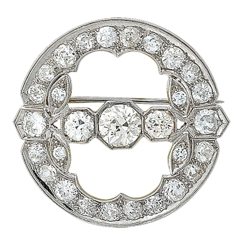 5.35CT DECO BROOCH-V6901-1: A striking tribute to the elegance of the Art Deco era, this platinum diamond brooch showcases the architectural beauty and geometric symmetry that define the period. Featuring a captivating 1.15-cara