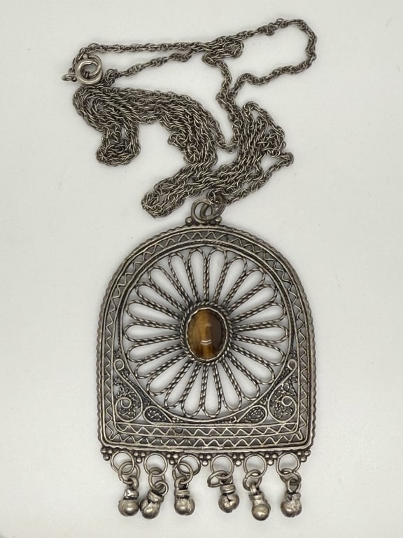 Vintage Silver Toned Tigers Eye Necklace: Vintage silver toned Bohemian style necklace with filigree and tigers eye pendant. Stamped 'SRA' verso. Some darkening of the pendant and minor signs of use, otherwise in good condition.