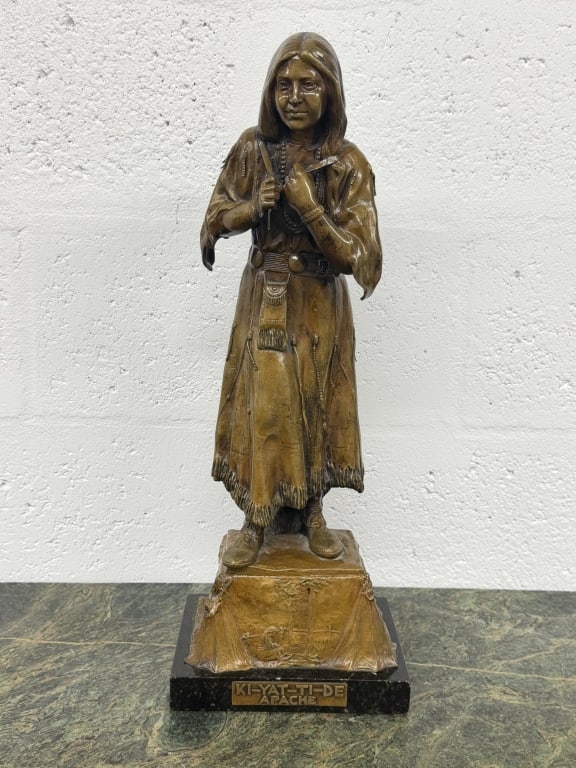 Carl Kauba / Ki-Yat-Ti-De Bronze sculpture: Carl Kauba Bronze Sculpture The Water Carrier (Ki-Yat-Ti-De) Bronze sculpture depicting a Native American woman standing in traditional dress, holding water vessels against her chest. The detailed