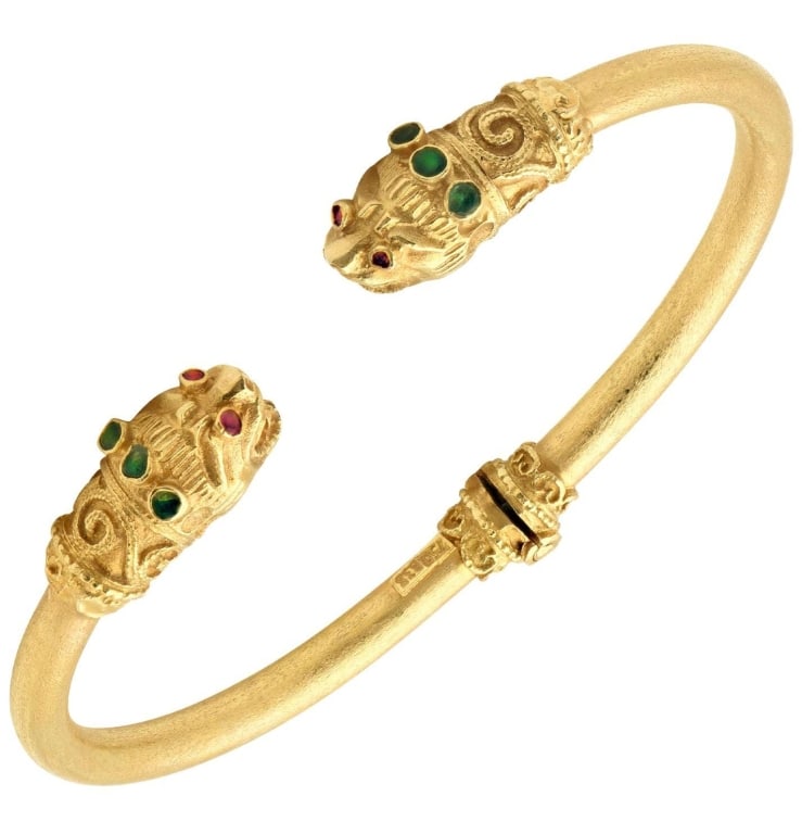 18K Yellow Gold Double Lion Cuff Bracelet: 18K Yellow Gold Double Lion Cuff Bracelet with Ruby Eyes & Emerald Accents – Vivid Diamonds SKU: 50646 Unleash your inner strength with this commanding Double Lion Cuff Bracelet, masterfully crafted