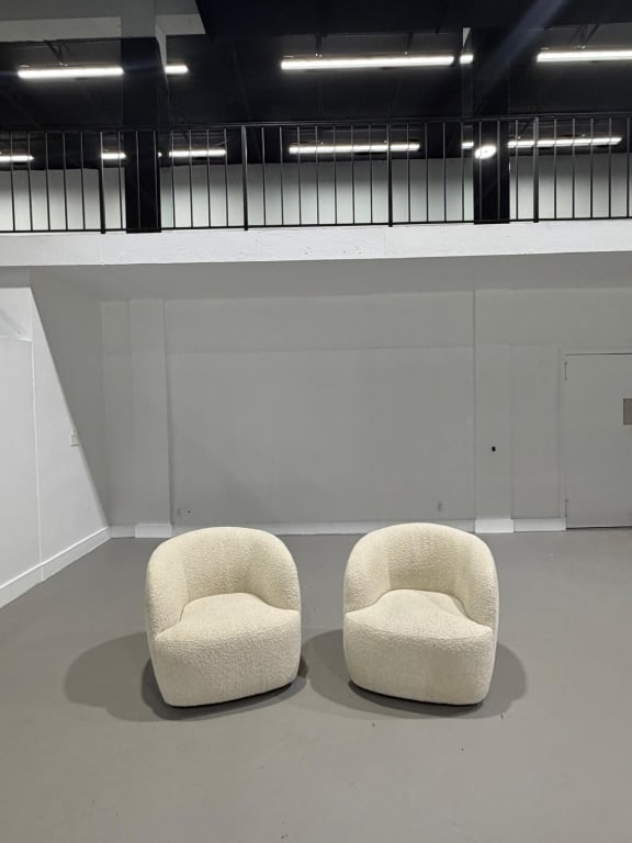A Pair of Boucle White Fabric Swivel Chairs: A Pair of Boucle White Fabric Swivel Chairs Measures: 30 inches high by 33 inches wide by 35 inches deep