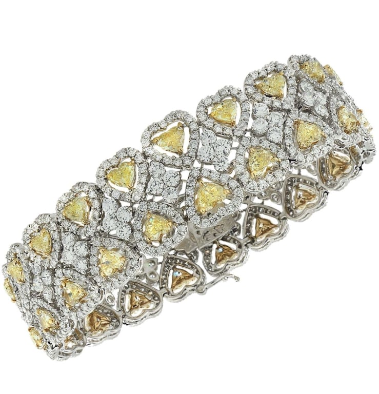 26.04 Ct Fancy Yellow Heart Diamond Halo Bracelet: 26.04 Ct Fancy Yellow Heart Diamond Halo Bracelet in 18K Gold SKU: 37984 Experience the allure of luxury with this stunning 26.04 Carat Fancy Yellow Heart Shape Diamond Halo Bracelet. This exquisite