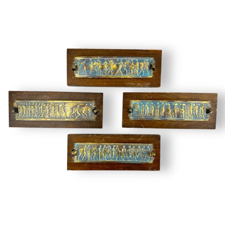 Set 4 Vintage Polychrome Metal Greek Wall Plaques: A set of four vintage polychrome blue and gold metal plaques. Metal plaques are mounted to wooden back plates with wall mountings. One metal panel shows inward dent near center, shows enamel/gold loss
