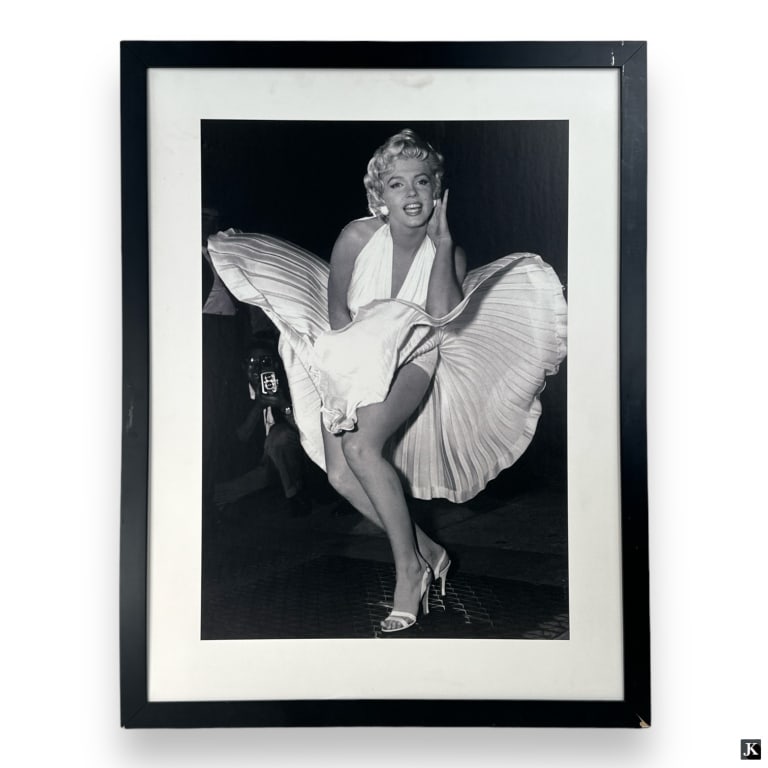 Print Of A Photograph Of Marylin Monroe Framed: Print of Marylin Monroe in white dress. Mounted in a black painted wooden frame behind acrylic screen. Measures approx. 33 3/4" height x 26" width overall including frame. Some nicking to frame.