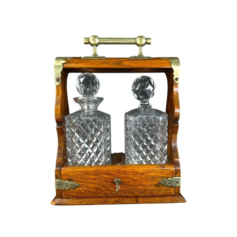 Antique English Wood And Glas Decanter Tantalus: Antique English wooden locking liquor tantalus with two glass decanters. One decanter had the neck shaved off, regular signs of age and use, otherwise in good condition. Measures approx. 13" height x 