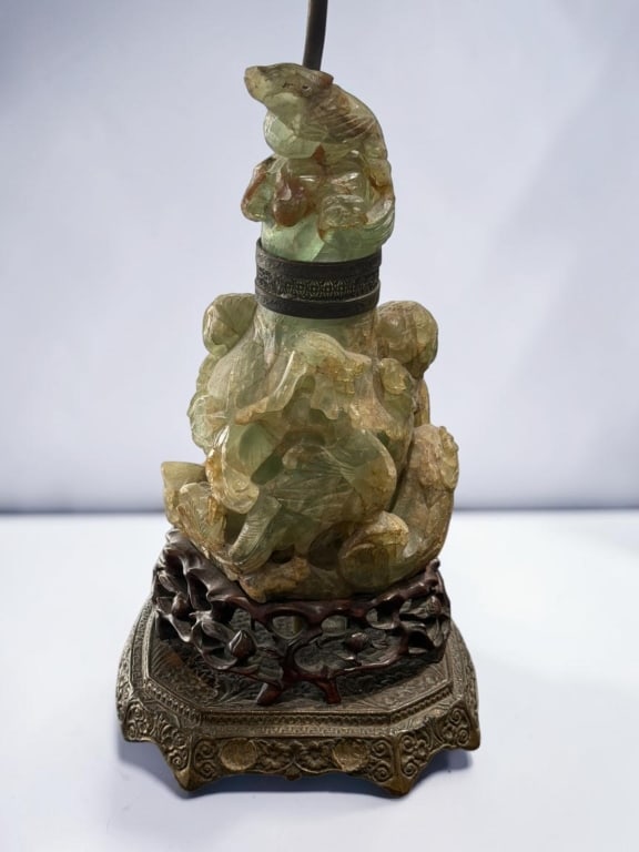 Chinese Carved Hardstone Lamp Base: Chinese Carved Hardstone Lamp Base Chinese carved hardstone lamp base featuring a translucent green stone sculpture with a frog motif amid foliage and naturalistic forms. Mounted on a carved wooden st