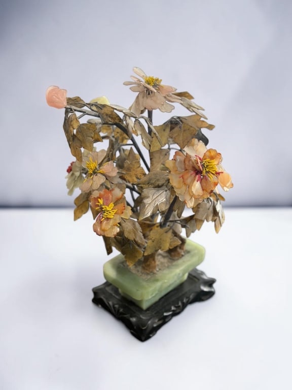 Chinese Hardstone Bonsai Tree Sculpture: Chinese Hardstone Bonsai Tree Sculpture Decorative Chinese hardstone bonsai tree featuring carved stone blossoms and leaves mounted on metal branches. The arrangement is set in a carved hardstone plan