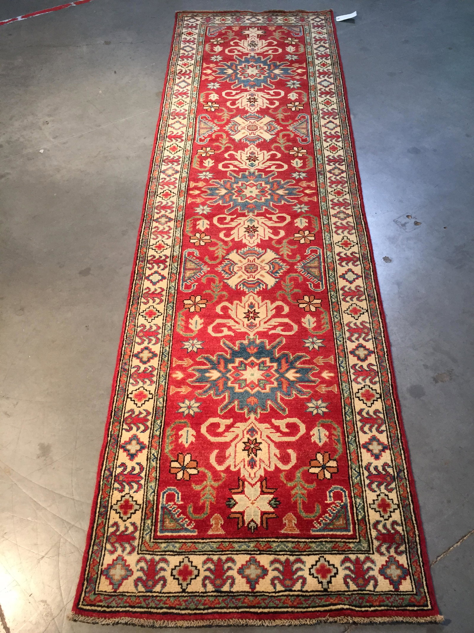 FINE HAND KNOTTED WOOL GEOMETRIC KAZAK RUNNER 2.6x10.3: 2'.6"X10'.3" Fine Authentic Hand Knotted 100% Veggie Dye Natural wool Pile Geometric pattern Kazak runner in decorative Red orange,Ivory and multi accent colors Hand Knotted in Pakistan