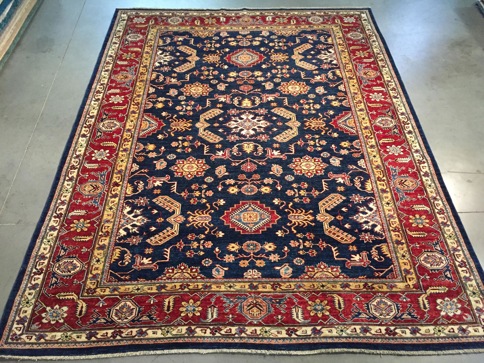 FINE HAND KNOTTED WOOL GEOMETRIC KAZAK RUG 8x10: 8x10 Fine Authentic Hand Knotted 100% Veggie Dye Natural wool Pile Geometric pattern super quality Kazak rug in Rich Navy Blue, rustic red and multi accent colors Hand Knotted in Pakistan