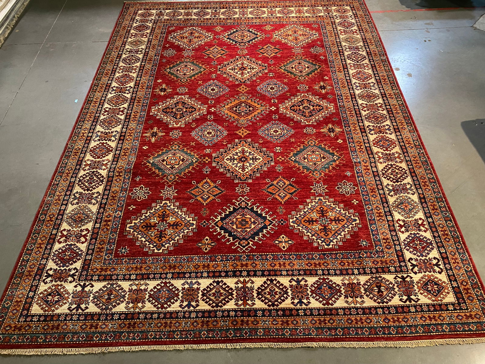 EXQUISITE FINE SUPER KAZAK RUG 8'.2"x11'.2": 8'.2"x11'.2" Super quality Unique design Kazak Rug, hand spun and hand knotted rug in Pakistan 100% Vegge Dye natural wool with luxurious sheen Pile , in Vivid Red, Ivory and multi accent colors.