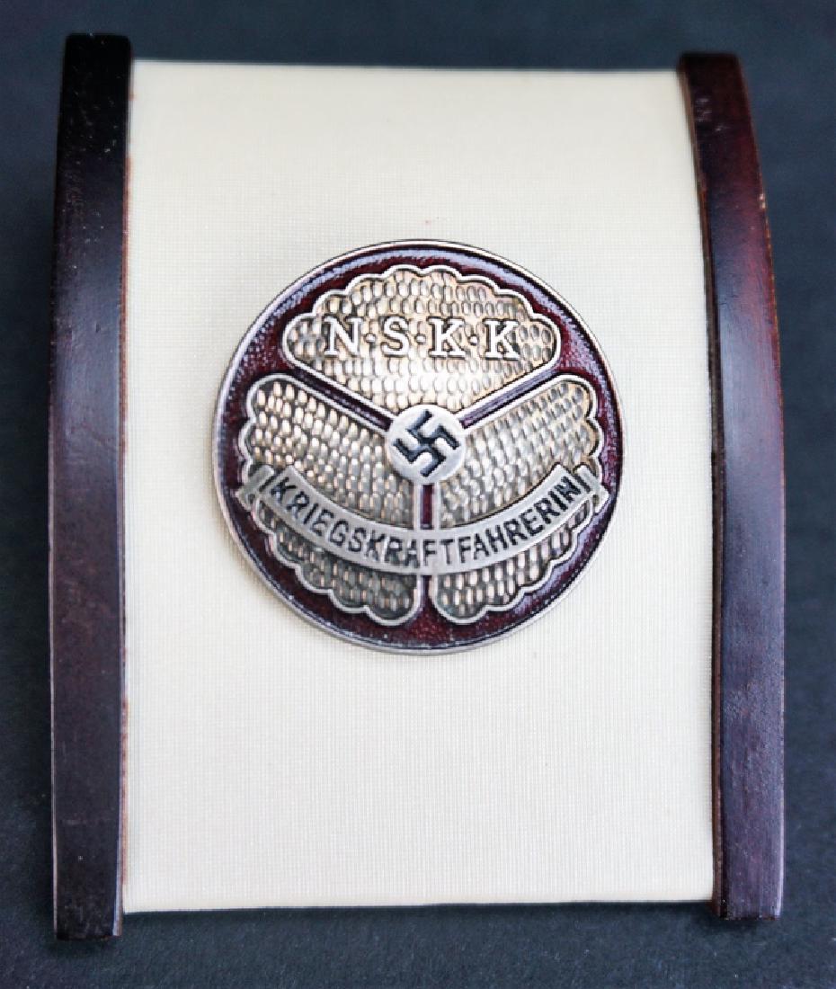 WWII NAZI MOTORCYCLE KOPS BADGE: WWII NAZI MOTORCYCLE KOPS BADGE - N.S.K.K. KRIEGSKRAFTFAHRERIN on front and M1/35 on back; Measures 1" diameter; Estimate: $50-$100
