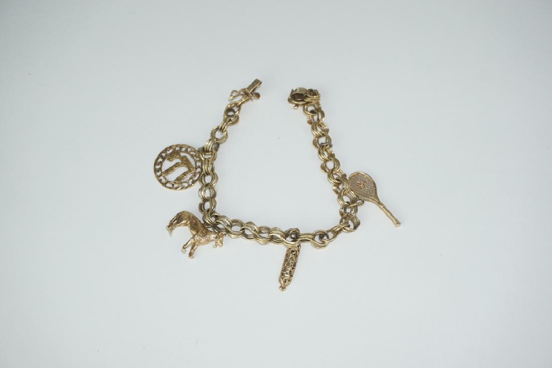 14K YELLOW GOLD CHARM BRACELET: 14K YELLOW GOLD CHARM BRACELET – 14k yellow gold triple-circle link bracelet with bracelet box clasp and 4 charm bracelets (Chinese symbol, dog, lantern, tennis racket) ; Measures: Total weight 21.1