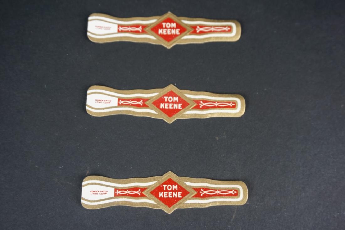 BOX OF TOM KEENE CIGAR LABELS/BANDS: BOX OF TOM KEENE CIGAR LABELS/BANDS - Made by Consolidated Lithographing Corporation, We estimate that there are 10,000 plus labels in box ; Condition - Box is taped on sides and open on one end, writ