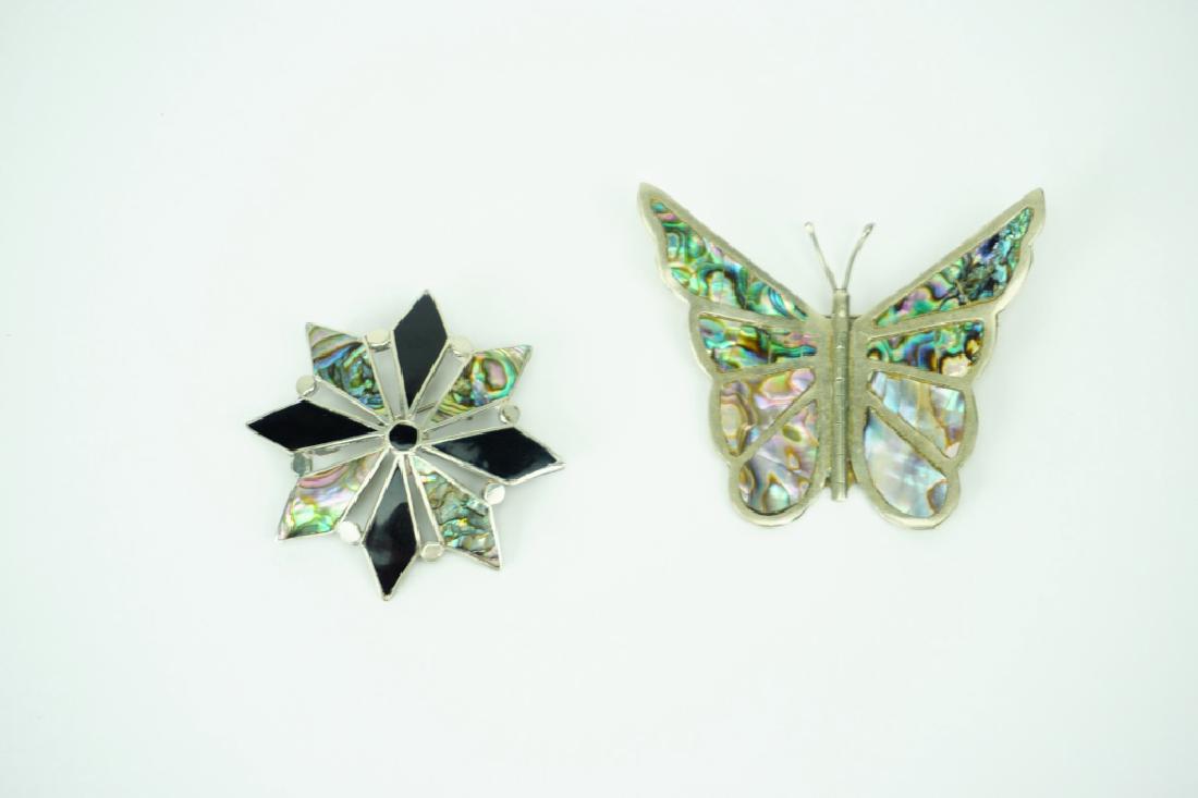 (2) MEXICO ABALONE BROOCHES: (2) MEXICO ABALONE BROOCHES – (1) silver toned butterfly with abalone decorating the wings and (1) snowflake/star with alternating onyx and abalone; Both marked Mexico