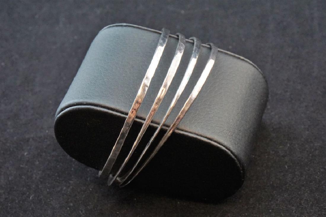 (4) STERLING ROBERT LEE MORRIS BANGLE BRACELETES: (4) STERLING ROBERT LEE MORRIS BANGLE BRACELETES – Hand hammered Sterling bangle bracelets, each flat on one side; by Robert Lee Morris ; Measures: Inside diameter: 2.5"; Total weight: 27g