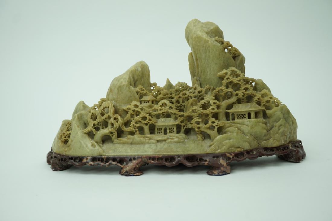 VINTAGE CHINESE CARVED SOAPSTONE LANDSCAPE: VINTAGE CHINESE CARVED SOAPSTONE LANDSCAPE Majority of the piece is celadon in color, with a burgundy base; Scene is of a mountain village surrounded by intricately carved trees ; Condition - Good con