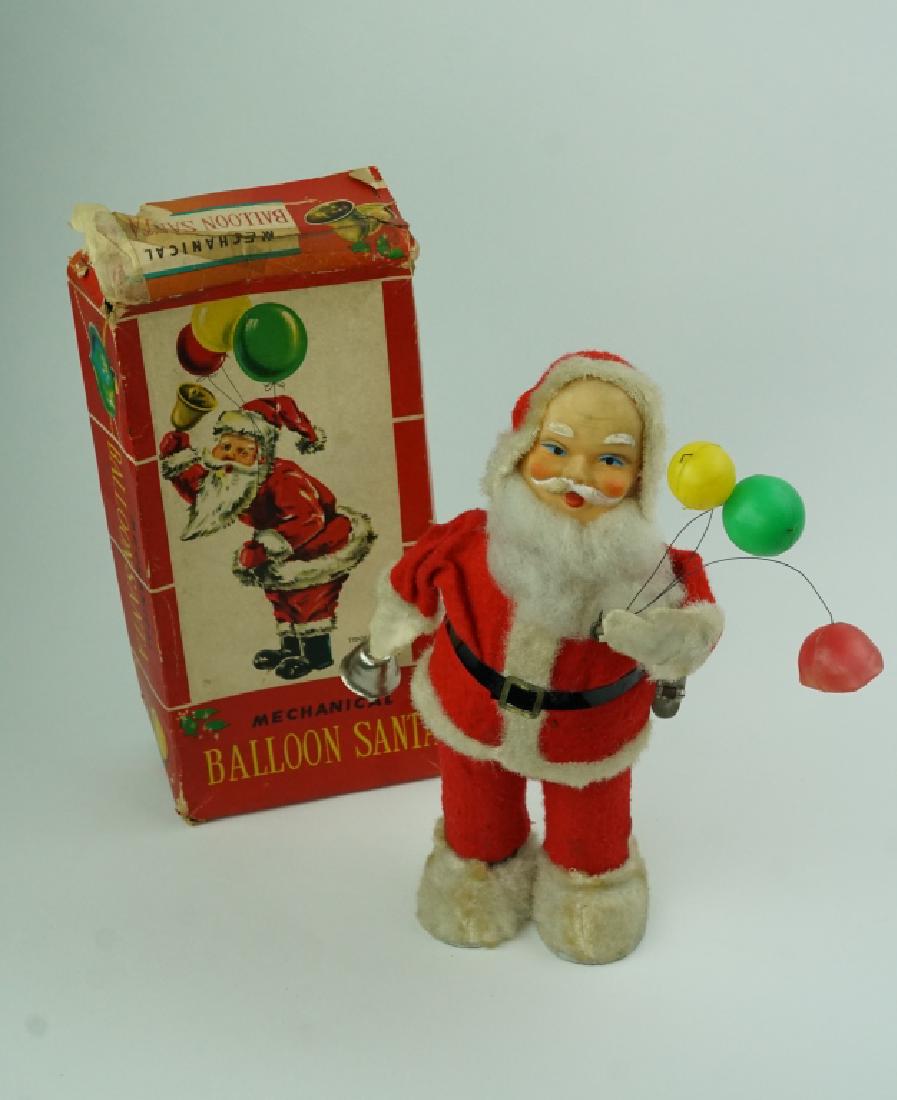 VINTAGE MECHANICAL BALLOON SANTA IN BOX: VINTAGE MECHANICAL BALLOON SANTA IN BOX Made in Japan by Alps. Santa is made of tin with cloth covering. After being wound up, his arm moves and he rings his bell. ; Condition - One balloon is dented,