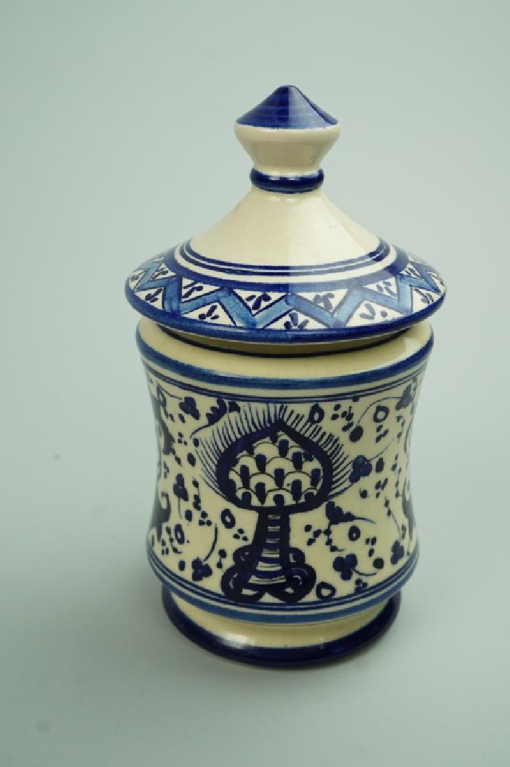 PATERNA MAJOLICA HAND PAINTED LIDDED JAR: PATERNA MAJOLICA HAND PAINTED LIDDED JAR Has blue & white pattern with figures and plants ; Condition - crazing, glaze loss on side of lid ; Measures: 6.75"H x 4" diameter