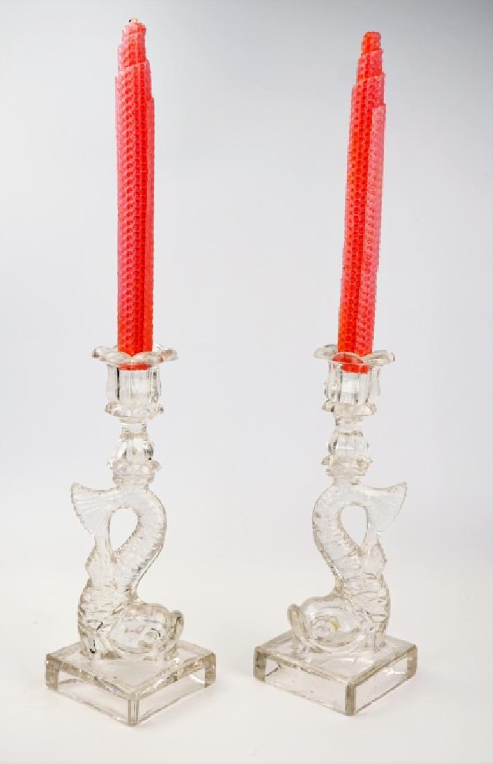 PAIR OF VINTAGE GLASS KOI CANDLE STICKS: PAIR OF VINTAGE GLASS KOI CANDLE STICKS Vintage pressed glass candlesticks featuring a koi fish design. Comes with pink candles. ; Condition - Has minor chipping on the bases and one of the fish tales