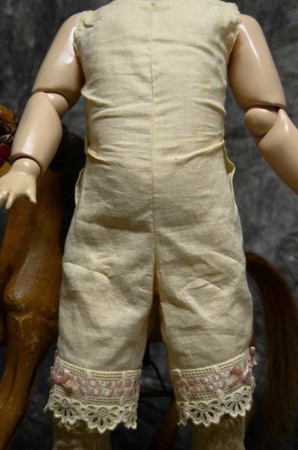 12" VINTAGE ONSIE FOR JUMEAU BEBE: CUTE VINTAGE ONSIE. LACE AND RIBBON ACCENTS ON THE BOTTOM OF THE LEGS. BUTTON CLOSURE IN THE BACK. THERE IS MINOR STAINING & IT'S MORE THAN LIKELY A LATER MADE PIECE, 1950'S FOR JUMEAU. WAIST LINE IS 