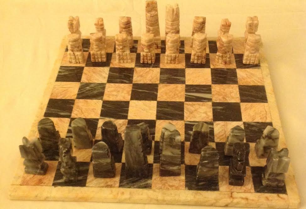 HAND CARVED MARBLE CHESS SET- COMPLETE: Description: Weighty marble Chess set with board that measure approximately 13.25 x 13.25â€. The board is a pinkish and light black color.Â There areÂ 32 playing pieces. Shipping:Domestic: Flat