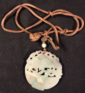Chinese Jade Amulet: Description: Gorgeous Chinese green jade carved amulet suspended on brown silk cord with single jade bead accent. Lovely mid-green shade with slightly darker variations throughout. Jade has been the
