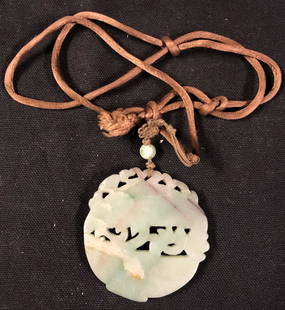 Chinese Jade Amulet: Description: Gorgeous Chinese green jade carved amulet suspended on brown silk cord with single jade bead accent. Lovely mid-green shade with slightly darker variations throughout. Jade has been the m