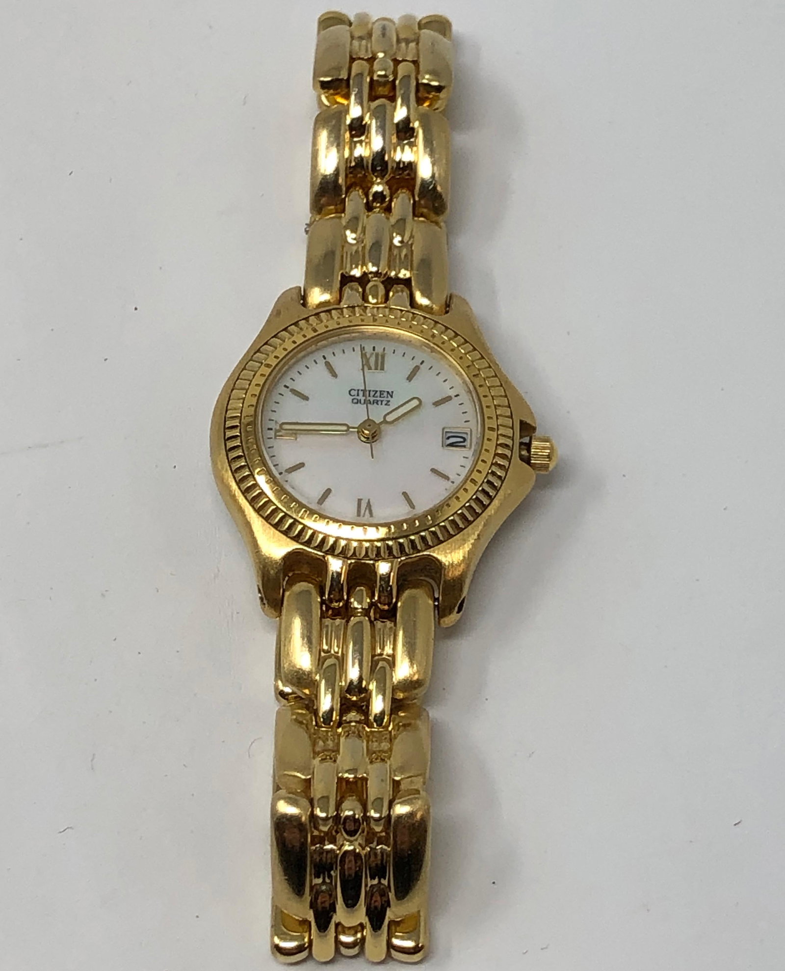 Ladies Citizen Quartz Watch: Description: Ladies Citizen Quartz watch in very attractive bright gold tone metal with a creamy, mother of pearl round face and date. Water resistant, 6010-614083, 540008, made in Japan. Material: me