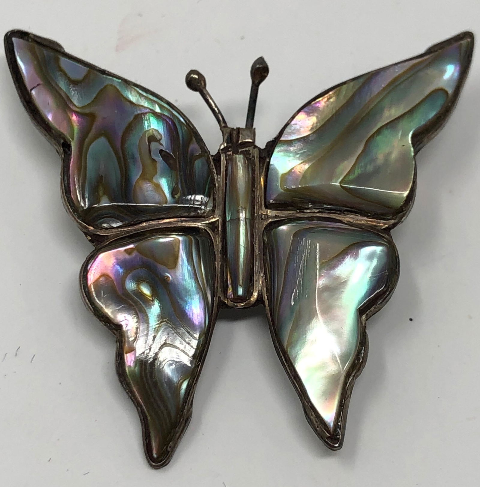 Sterling and Abalone Butterfly Brooch: Description: Delightful sterling and abalone butterfly brooch; hallmarked on reverse side. Material: sterling; shell. Measurement: approximate 1.50" (INCHES). Shipping: $15; different rate to Alaska,
