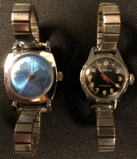 Vintage Ladies Caravelle Watches: Description: Pair of vintage ladies Caravelle watches with mesh bands; self winding. One has a pretty blue face, is water resistant with stainless steel back; the other has an interesting black face