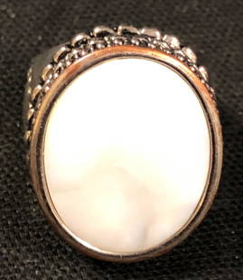 Mother of Pearl Ring: Description: Statement worthy mother of pearl ring set in heavy silver metal with filigree accents. Luminous mother of pearl cachabon set in center. Material: mother of pearl; metal. Measurement: