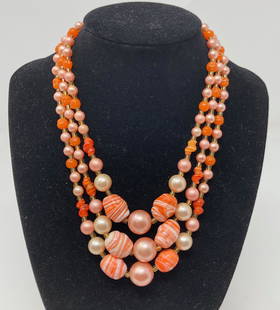 Tangerine Color Beaded Torsade: Description: Perfect for winter vacations in warmer climates Vintage yummy tangerine colored beaded torsade; strung on metal chain. Shades range from a delicate pale pink to orange; choker length,