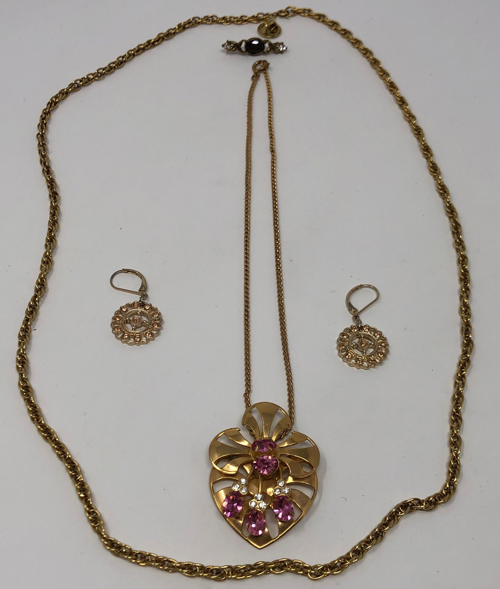 Vintage Gold Tone Necklace, Earring, Brooch Set: Description: Splendid set of gold tone, vintage jewelry, including a pin/pendant with pink and clear crystals, suspended on a link necklace, a longer, rope-style necklace, pierced earrings in pretty o