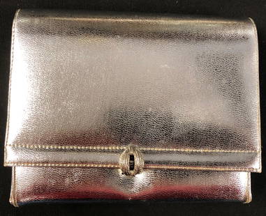 Silver Leather Small Evening Bag: Description: Small, genuine leather silver evening bag with small strap that can be tucked inside purse. Small interior pocket; black lining; decorative silver tone clasp. Measurement: approximate 5"