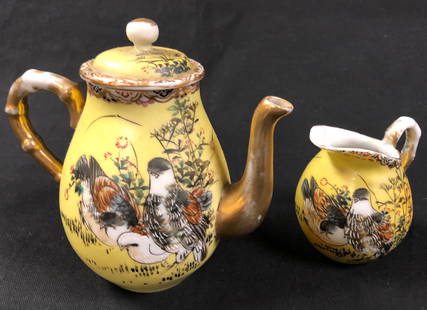 Antique Asian Porcelain Teapot and Creamer: Description: Petite antique teapot and creamer, hand painted with an Asian-themed design over a lovely and unusual deep yellow, with gilt accents on handles, spout and rim. Small chip on underside of