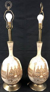 Fabulous Vintage Glass Table Lamps: Description: Fabulous pair of vintage table lamps; frosted white glass body with gold gilt applique depicting European city scene. Silver accents overhead depict small birds in flight. Possibly circa